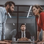 angry couple staring at eachother over office table during divorce mediation