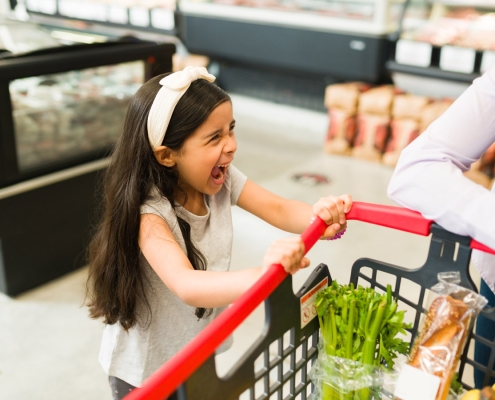 little girl throwing a tantrum in a grocery store