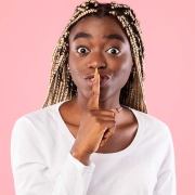 Woman looking at you and making a shush gesture