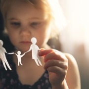 little girl with paper family in hands